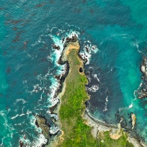 Beautiful overhead aerial shot of coral reefs in the middle of the ocean with amazing ocean waves