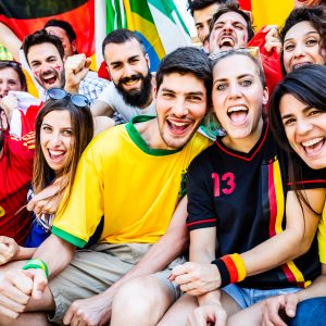 Diverse football fans cheering together at a stadium