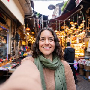 Happy woman taking selfie visiting Istanbul bazaar