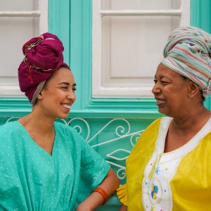 Happy african mother and daughter having fun together in front o